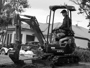 Jack operating a mini excavator preparing a front yard