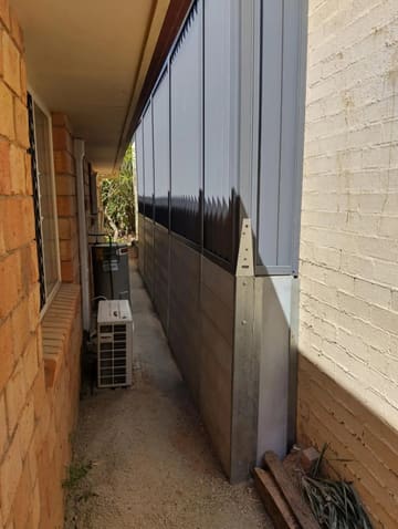 Plain Grey concrete sleeper wall and Woodland Grey Colorbond fence in a narrow side path