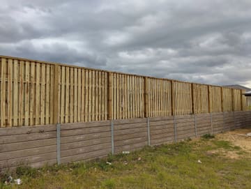 New treated pine timber fence along the top of an existing concrete sleeper retaining wall