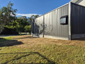 Monument Colorbond fence on Plain Grey sleepers on a corner block with a built-in letterbox