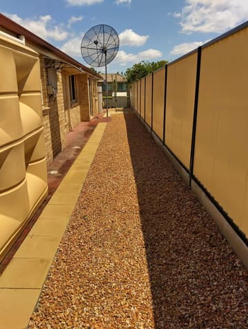 Long gravel side path with a paver edge beside a brick house