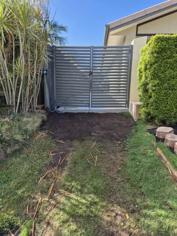 Woodland Grey horizontal aluminium slat double gates beside a house