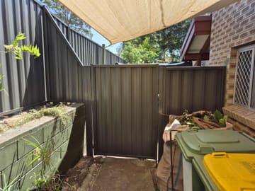 Woodland Grey Colorbond gate and raked fence panel beside a retaining wall
